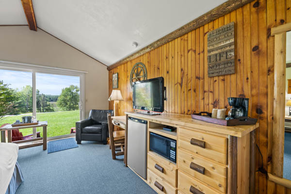 room with custom made furniture, bed and desk with TV and patio view