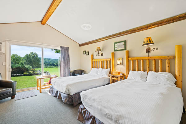 room 10 features two extra long double beds (same length as a king bed) with duvet comforters. And a patio view of the great lawn.