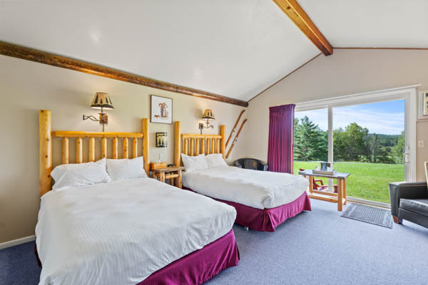 room 2 features two extra long double beds (same length as a king bed) with duvet comforters. patio and lawn view.