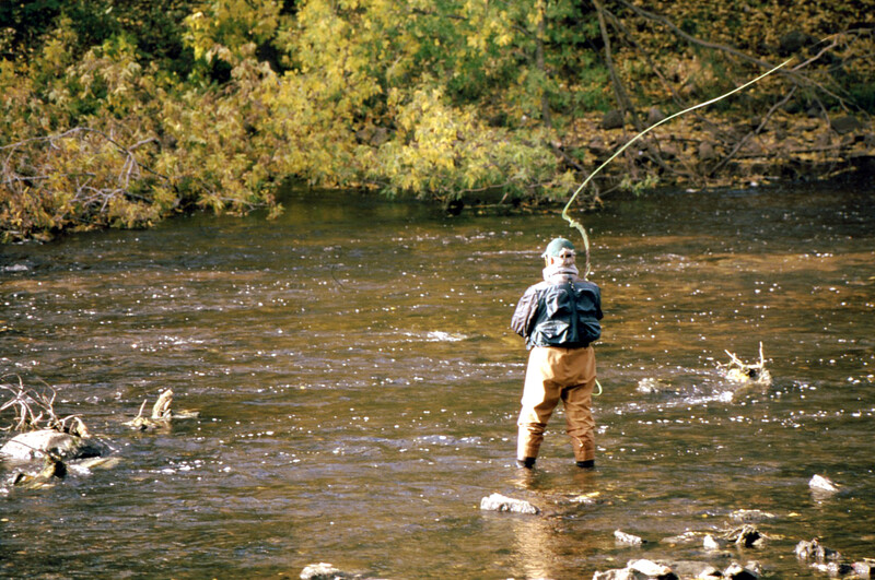 man in stream fishing