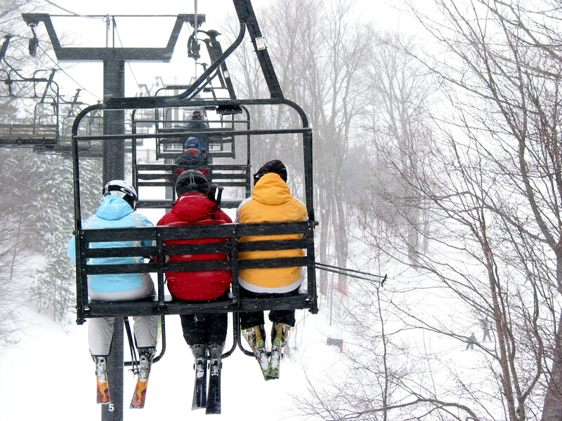 three people on chair lift in snow